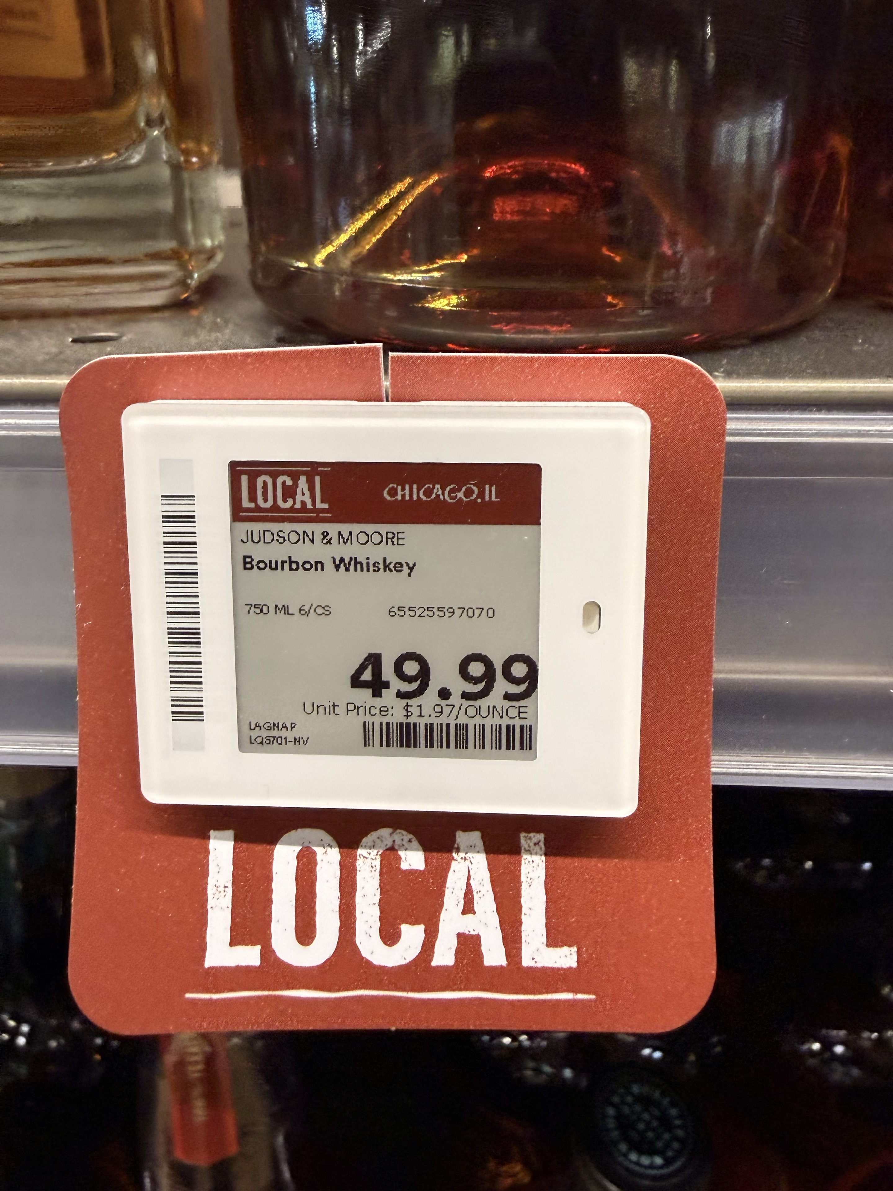 Whole Foods shelf tag for Judson & Moore Bourbon Whiskey showing 49.99 and a Chicago local marker